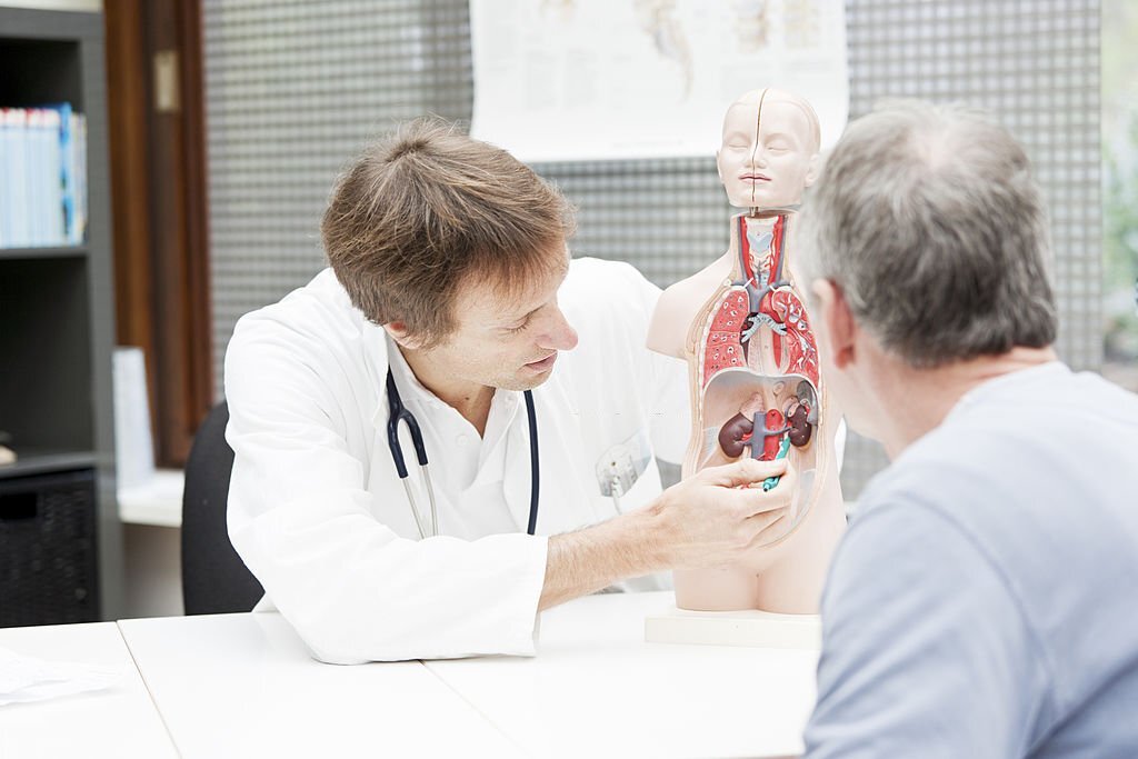 A medicine,explaining urological problems to a patient.